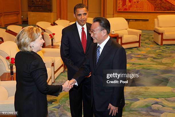 Secretary of State Hillary Clinton shakes hands with Wu Bangguo, Chairman of China's National People's Congress as U.S. President Barack Obama...