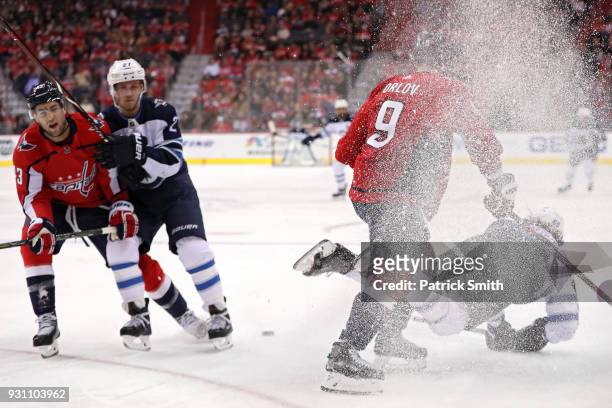Mathieu Perreault of the Winnipeg Jets is checked by Dmitry Orlov of the Washington Capitals during the first period at Capital One Arena on March...