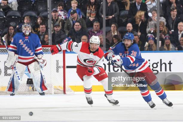 Mats Zuccarello of the New York Rangers skates with the puck against Justin Williams of the Carolina Hurricanes at Madison Square Garden on March 12,...