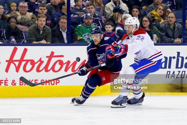 Mark Letestu of the Columbus Blue Jackets and Karl Alzner of the Montreal Canadiens battle for control of the puck during second period on March 12,...