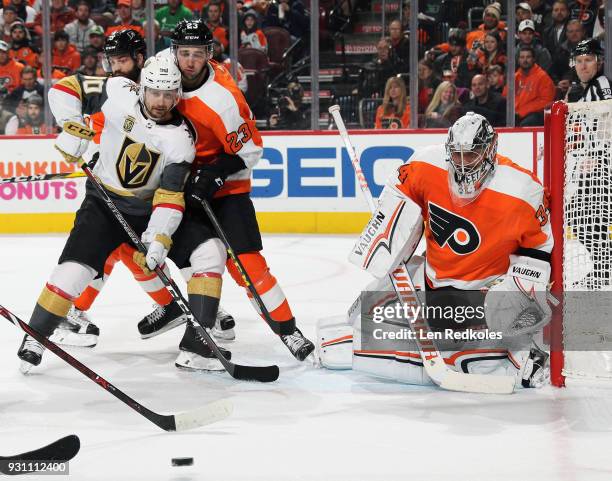 Petr Mrazek of the Philadelphia Flyers protects his crease as Brandon Manning defends against Tomas Tatar of the Vegas Golden Knights on March 12,...