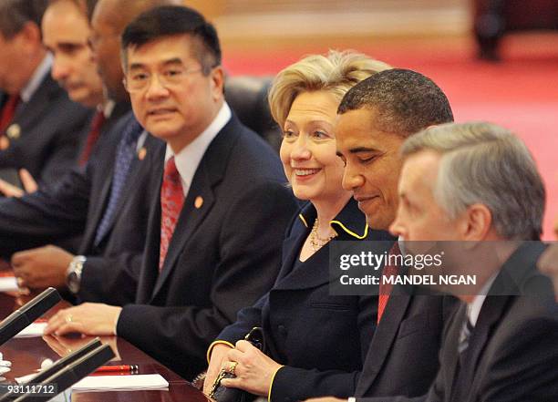 President Barack Obama smiles while seated with Secretary of State Hillary Clinton and Commerce Secretary Gary Locke as they take part in an expanded...