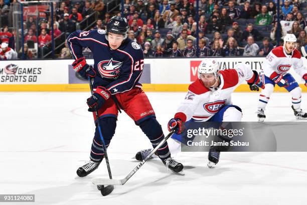 Sonny Milano of the Columbus Blue Jackets attempts to turn the puck away from Karl Alzner of the Montreal Canadiens during the third period of a game...