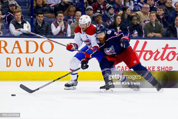 Ian Cole of the Columbus Blue Jackets and Jeff Petry of the Montreal Canadiens battle for control of the puck during the third period on March 12,...