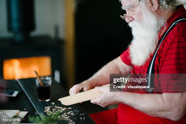 santa claus cutting wood - santas workshop stock pictures, royalty-free photos & images