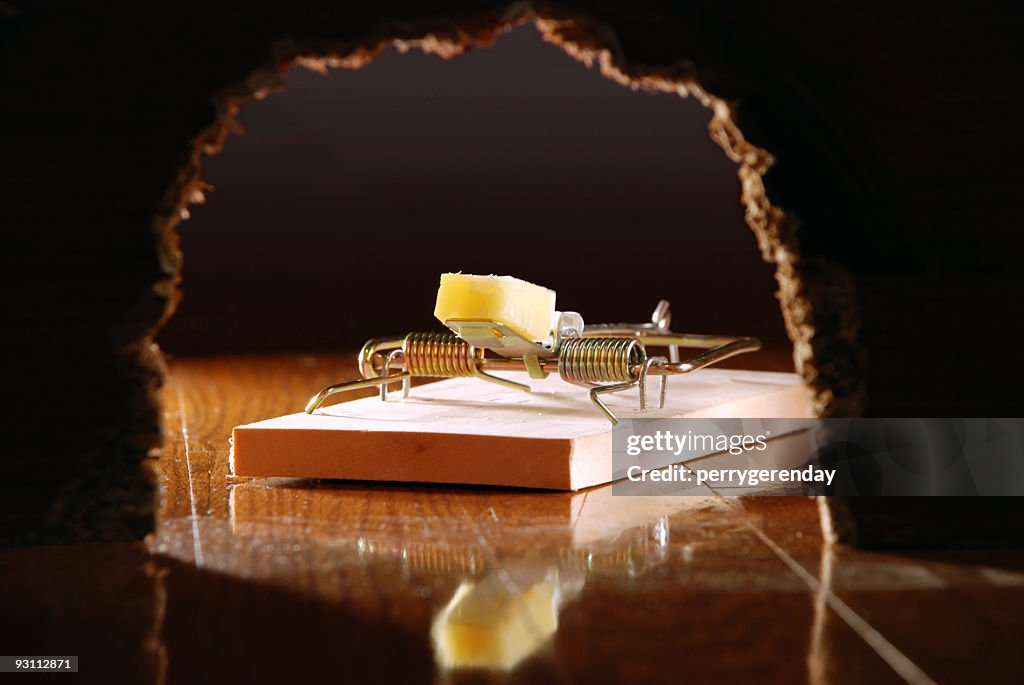 Piège à souris et fromage à travers mur trou