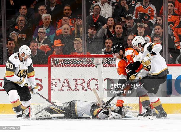 Marc-Andre Fleury of the Vegas Golden Knights stops a shot by Claude Giroux of the Philadelphia Flyers in the third period as teammates Tomas Tatar...
