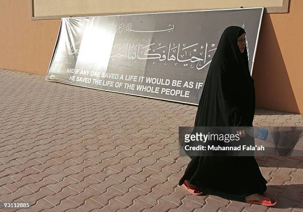 An Iraqi woman walks past verses of Holy Quran on November 12, 2009 at Falluja General Hospital in the city of Falluja west of Baghdad, Iraq. Birth...
