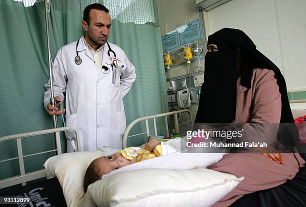 Iraqi Dr. Aiman Qeis speaks with an Iraqi woman with her sick child on November 12, 2009 at Falluja General Hospital in the city of Falluja west of...