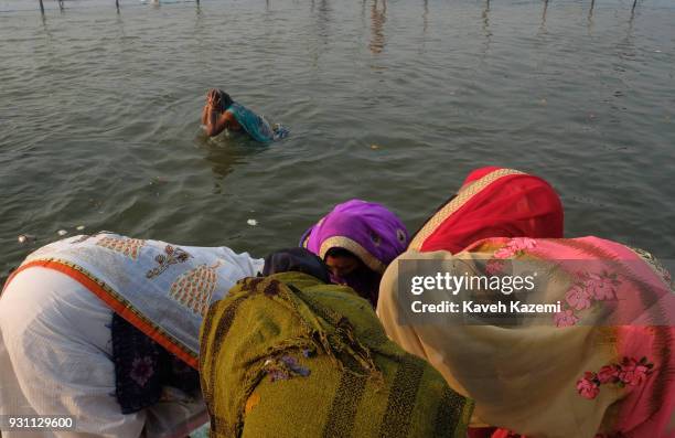 Female Indian Hindu devotee seen taking a holy dip in Sangam which is the point of confluence of River Ganga, Yamuna and Mythological invisible...