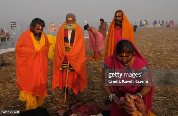 Woman gets dressed behind Hindu Sadhus after a holy dip in Sangam during Magh Mela Festival on January 27, 2018 in Allahabad, India. Sangam is the...