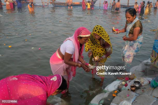 The Indian Hindu devotee women offer flowers and candle light by releasing them into Sangam during Magh Mela Festival on January 27, 2018 in...