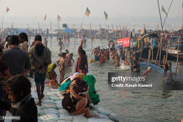 Hindu devotees seen bathing and offering prayers in Sangam during Magh Mela Festival on January 27, 2018 in Allahabad, India. Sangam is the point of...