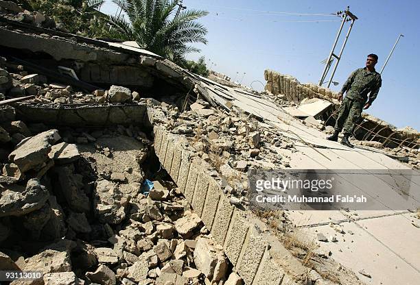 An Iraqi policeman stands over a house, damaged in Falluja battle between the U.S military and insurgents in 2004 on November 12, 2009 in the city of...