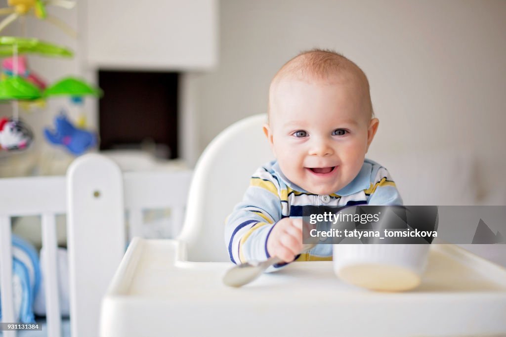 Lindo bebé niño, comer puré de verduras para el almuerzo, mamá le