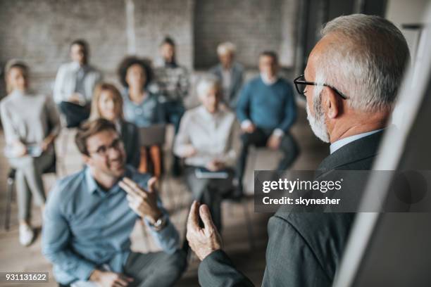 senior manager talking to large group of his colleagues on a business seminar. - retirement plan imagens e fotografias de stock