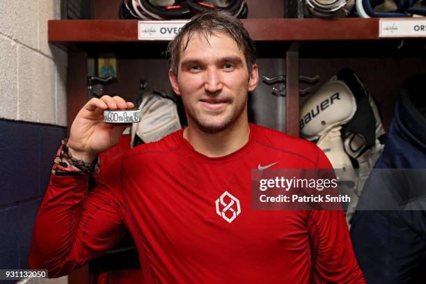 Alex Ovechkin of the Washington Capitals poses with the puck commemorating his 600th career goal in which he scored during the second period against...