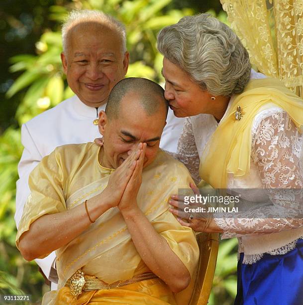 Cambodia's new King Norodom Sihamoni is kissed by his mother Queen Norodom Monineath while his father, former King Norodom Sihanouk looks on during a...