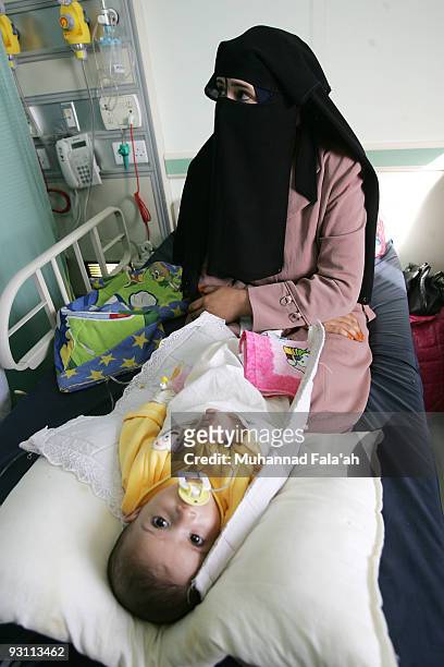 An Iraqi woman sits with her sick child on November 12, 2009 at Falluja General Hospital in the city of Falluja west of Baghdad, Iraq. Birth defects...