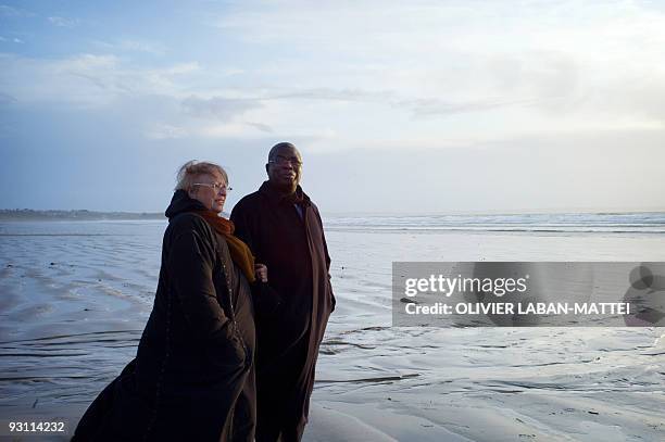 Franco-Togolese dual national politician Kofi Yamgnane walks with his wife Anne-Marie on the beach of Saint-Nic, western France, on November 14,...