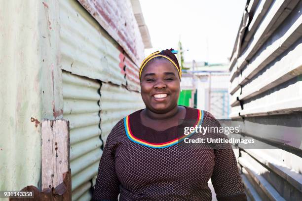 madre sonriente permanente al aire libre - slum fotografías e imágenes de stock