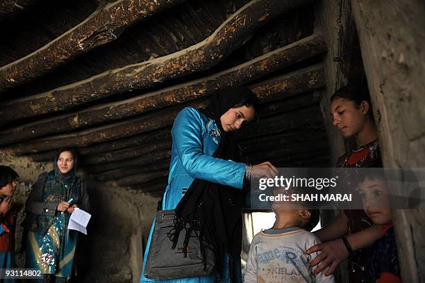 An Afghan health worker administers polio vaccine to a child on the second day of a vaccination campaign in Kabul on November 16, 2009. A new...