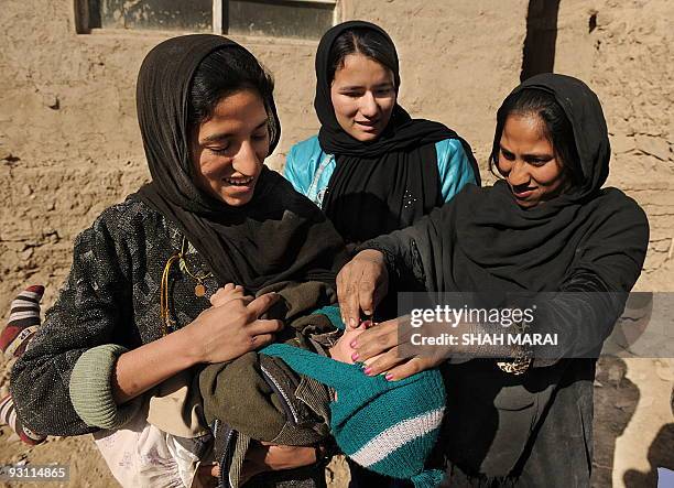 An Afghan health worker administers polio vaccine to a child on the second day of a vaccination campaign in Kabul on November 16, 2009. A new...