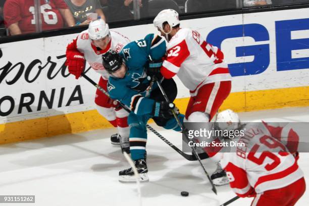 Joonas Donskoi of the San Jose Sharks battles against Gustav Nyquist and Jonathan Ericsson of the Detroit Red Wings for the puck at SAP Center on...