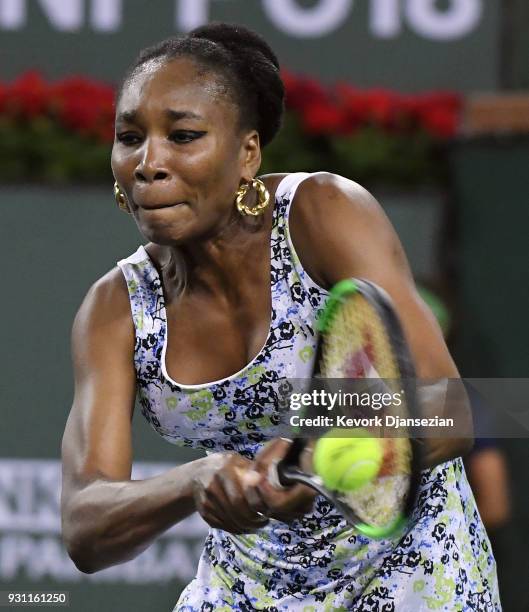 Venus Williams of United States hits a backhand against her sister Serena Williams of United States during Day 8 of BNP Paribas Open on March 12,...