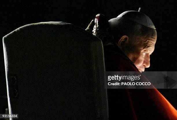 Pope John Paul II looks on from the Palatine Hill during the Stations of the Cross ceremony in Rome 18 April 2003. The 82-year-old pontiff this year...