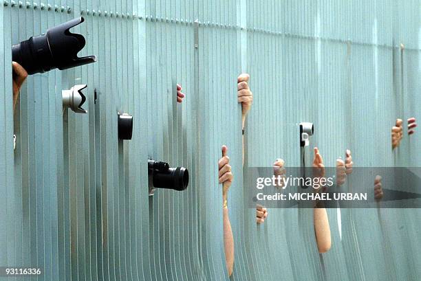 Photographers and onlookers peer through the gates of the Chancellery to catch a glimpse of German Chancellor Gerhard Schroeder meeting with EC...