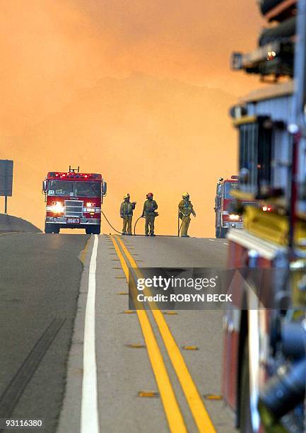 Firefighters crest a hill on the 118 freeway, 27 October 2003, in Simi Valley, CA as they work to keep the blaze on the north side of the highway....