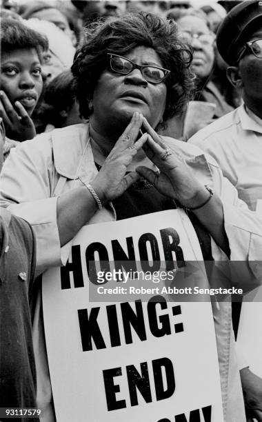 Close-up of a woman who holds a sign that reads, in part, 'Honor King,' a reference to the recently assassinated Civil Rights leader Dr. Martin...
