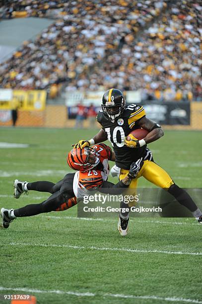 Defensive back Leon Hall of the Cincinnati Bengals tackles wide receiver Santonio Holmes of the Pittsburgh Steelers during a game at Heinz Field on...