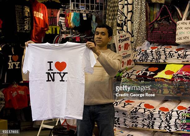 Street vendor on 7th Avenue near Broadway and Times Square holds up a "I Love New York" t-shirt in this 2009 New York, NY, early afternoon cityscape...