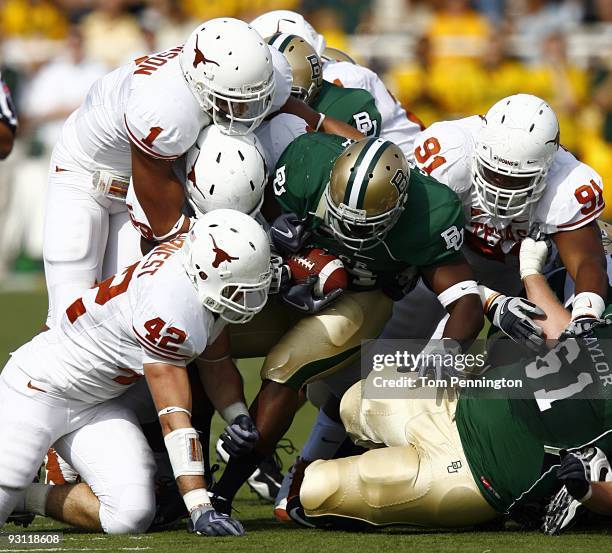 Running back Terrance Ganaway of the Baylor Bears carries the ball against linebacker Dusting Earnest, linebacker Keenan Robinson, and tackle...