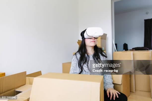 young woman using vr in her new house - cardboard vr stock pictures, royalty-free photos & images