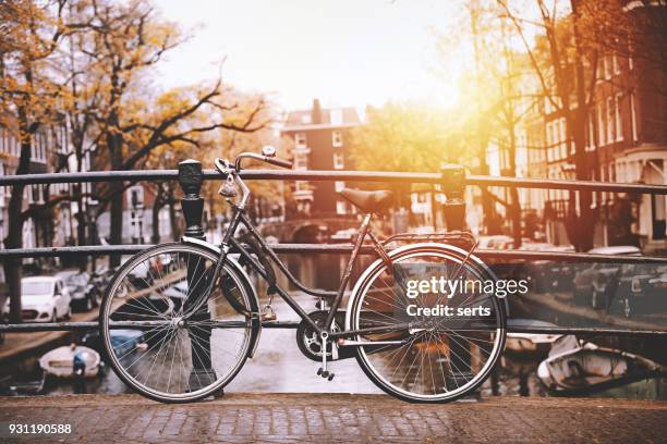 bicycles parked on a bridge in amsterdam - amsterdam stock pictures, royalty-free photos & images