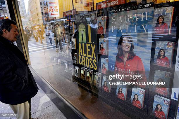 People walk by a window display of "Going Rogue: an American Life", a book from former Republican vice-president candidate Sarah Palin, as it hit...