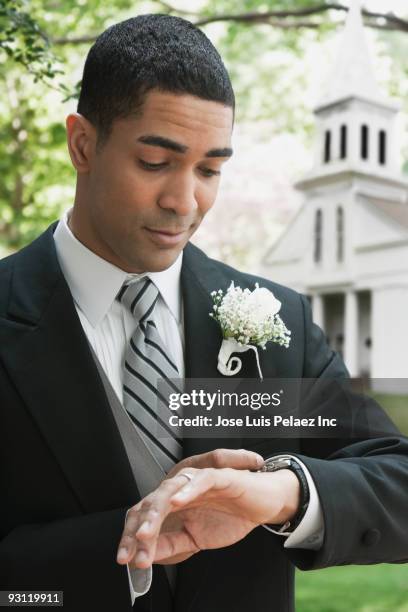 groom checking wristwatch - boutonniere ストックフォトと画像