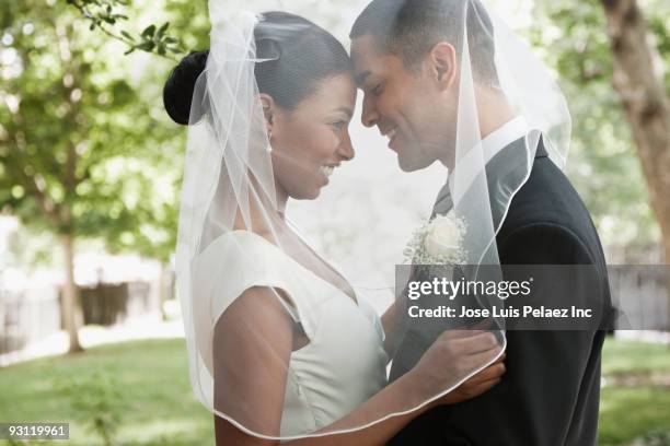 bride and groom hugging under veil - bruidspaar stockfoto's en -beelden