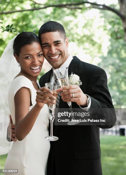 bride and groom toasting champagne glasses - black couple wedding stock pictures, royalty-free photos & images