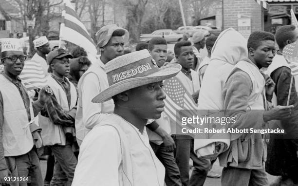 Man with a straw hat that reads 'Freedom' on its band walks with others during on the Selma to Montgomery marches held in support of voter rights,...