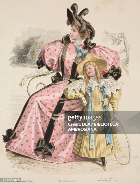 Seated woman wearing a pink polka dot walking dress with bows and brown ribbons, little girl wearing a yellow dress with lace collar and blue...