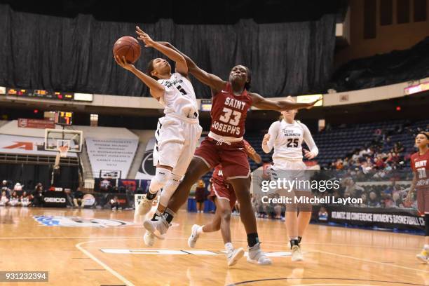 Brianna Cummings of the George Washington Colonials goes up for a shot against Adashia Franklyn of the St. Joseph's Hawks during the Championship...