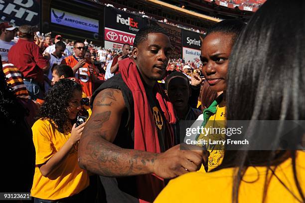 Clinton Portis of the Washington Redskins signs autographs before the game against the Denver Broncos at FedExField on November 15, 2009 in Landover,...