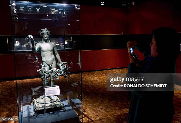 Journalist looks at a sculpture on display as part of the exhibition "Pompeya and a Roman Villa" in the National Museum of Anthropology and History...