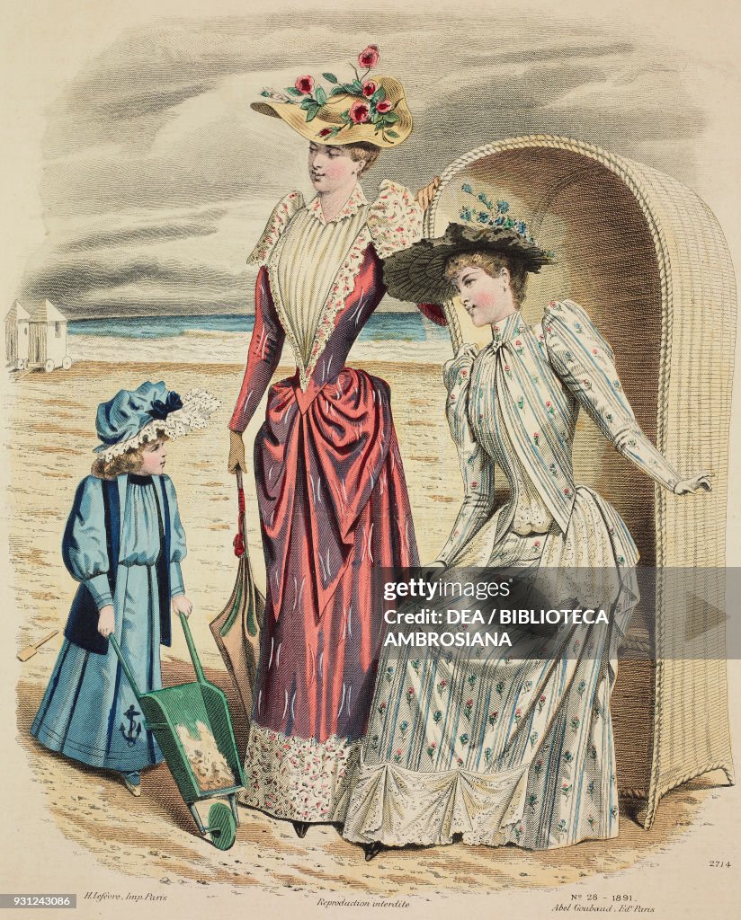 Women and girl on the beach wearing dresses