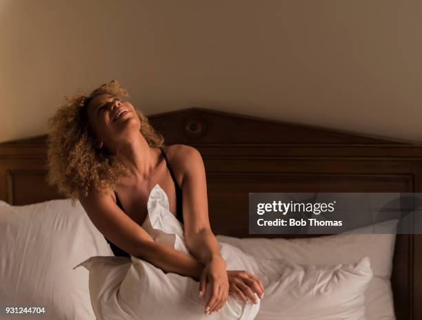 mixed race woman wearing lingerie sitting on a bed - mulher sedutora - fotografias e filmes do acervo