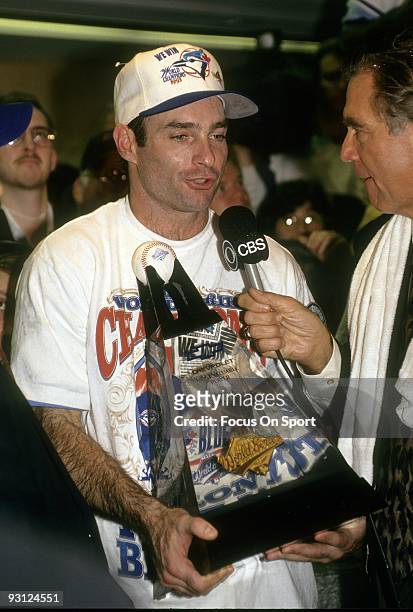 Infielder Paul Molitor of the Toronto Blue Jays holding the World Series MVP trophy talks with CBS comintator Tim McCarver in the Blue Jays locker...